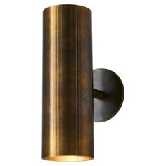 a brass colored wall light with a cylindrical cylinder on the front and back of it