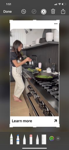 the woman is cooking in the kitchen on her cell phone, and she's looking for something to eat