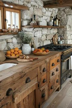 a rustic kitchen with stone walls and wooden cabinets is pictured in this image, there are fruit on the counter