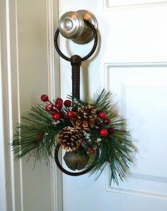 a door handle decorated with pine cones and berries