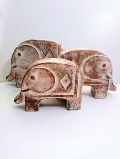 three ceramic elephants sitting next to each other