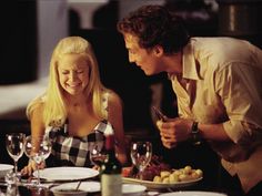 a man and woman sitting at a dinner table