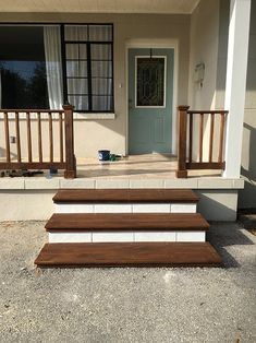 the steps are made out of wood and white bricks, along with a blue door