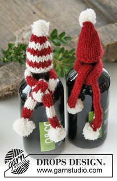 two bottles with knitted hats and scarfs on them sitting next to each other