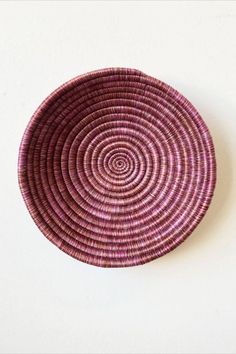 a purple basket sitting on top of a white wall