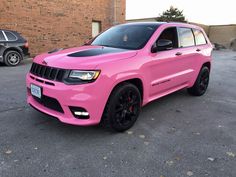 a bright pink jeep parked in a parking lot