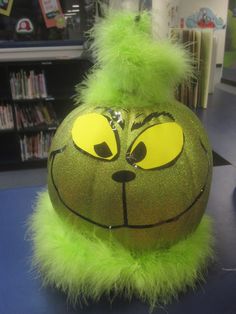 a green stuffed animal sitting on top of a table