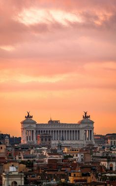 the skyline of rome at sunset with an old building in the foreground and some buildings to the right