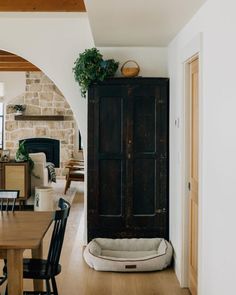 a dog bed in the middle of a living room next to a dining room table