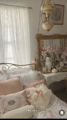 a white bed sitting in a bedroom next to a window with curtains on top of it