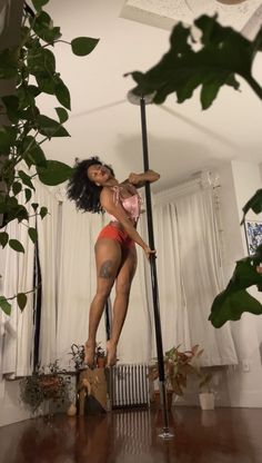 a woman in red panties and high heels standing on a pole