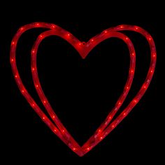 a red heart shaped light up sign on a black background