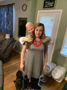 an older man and woman standing in a living room with their arms around each other