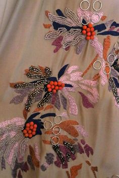 the fabric has been embroidered with flowers and leaves, but is still attached to it