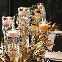 the centerpieces are decorated with candles, flowers and greenery in glass vases