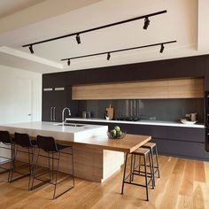 an open kitchen with wooden floors and black cabinets