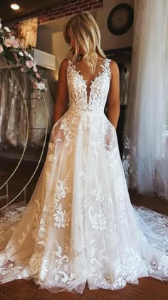 a woman in a white wedding dress standing on a wooden floor with her back to the camera