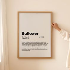 a woman pointing at a poster with the words bulloxer in black on it