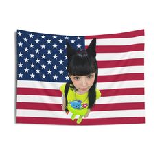 a girl with black hair and green shirt in front of an american flag wall hanging