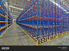 an empty warehouse filled with lots of blue and orange shelves