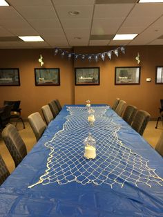 a long table covered in blue cloth with candles on it