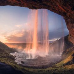 an image of a waterfall coming out of the ground at sunset or sunrise with water gushing from it