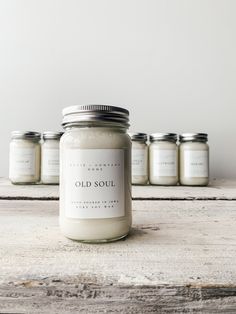 six jars of old soul candles sitting on a table