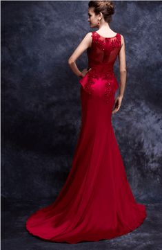 a woman in a long red dress with an open back and lace on the top