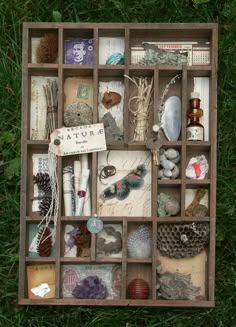 a wooden box filled with lots of different items on top of green grass covered ground