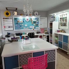 a room with a desk, chair and shelves filled with crafting supplies on it