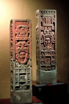 two stone sculptures sitting on top of a wooden table