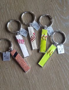 six different types of key chains with baseballs and bats on them sitting on a table