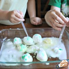 two children making marshmallows in a glass dish