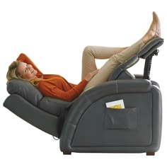 a woman laying on top of a gray recliner