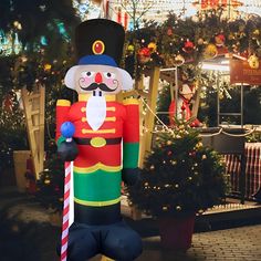 an inflatable nutcracker is standing next to a christmas tree