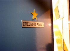 there is a sign that says dressing room on the wall next to a door with a star