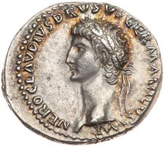 an ancient roman coin with a woman's head on the reverse, and words written in cursive writing