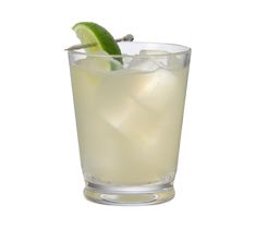 a tall glass filled with ice and lime