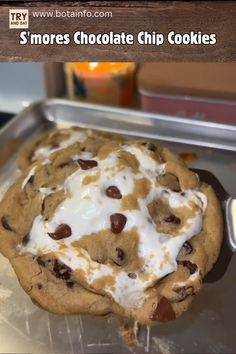 a chocolate chip cookie with white icing on it and the words s'mores chocolate chip cookies