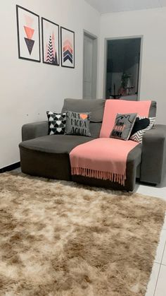 a living room with a couch and rugs on the floor in front of it