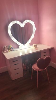 a white desk with a heart shaped mirror on it