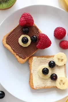 two pieces of toast with fruit on top and chocolate spread, topped with bananas and raspberries