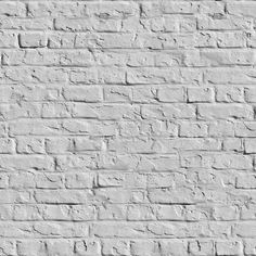 an old white brick wall is shown in black and white