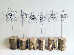 four wooden logs with wire flowers in them