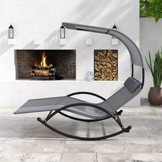 an outdoor lounge chair in front of a fireplace