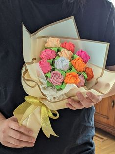 a person holding a bouquet of flowers in their hands and wearing a black t - shirt