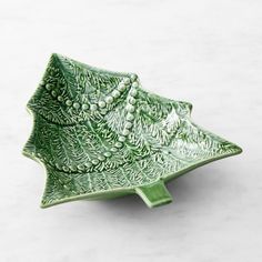 a green leaf shaped dish sitting on top of a table