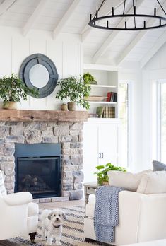 a living room filled with furniture and a fire place in front of a stone fireplace