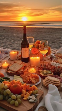 a table with wine, cheeses and crackers on it next to the ocean