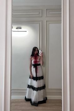 a woman standing in front of a mirror taking a selfie